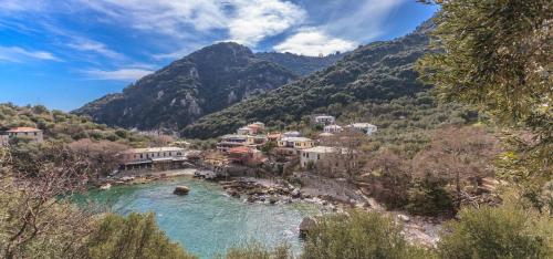 a village on a river with mountains in the background at Kastro Studios in Damouchari