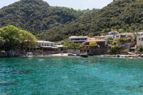 a group of houses on the shore of a body of water at Kastro Studios in Damouchari