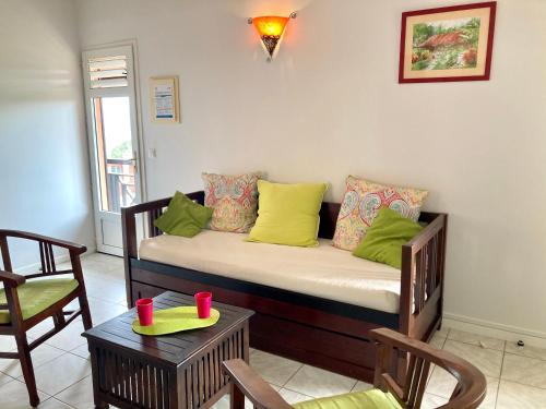 a couch in a room with chairs and a table at Habitation Bellevue in Sainte-Anne