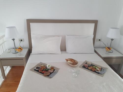 a bed with two plates of food on it at Elizabeth Suites in Kato Daratso