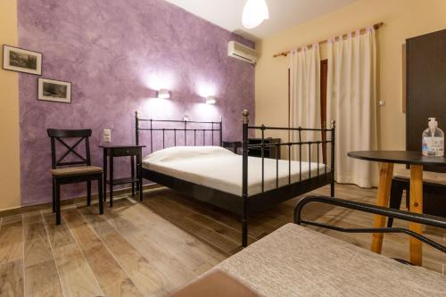 a bedroom with a bed and a table and chairs at Kastro Studios in Damouchari