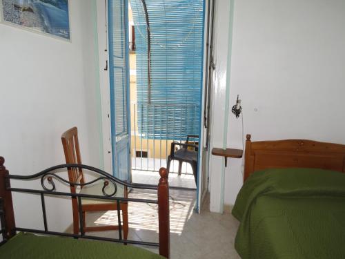 a bedroom with a bed and a window and a chair at Casa Vittorio B&b in Lipari