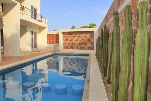 a swimming pool in front of a house with a retaining wall at La Aurora in Puerto Escondido