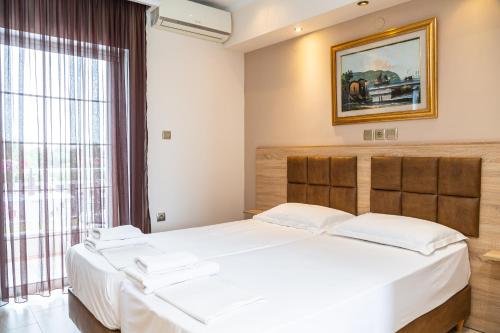 a bedroom with two beds and a window at Sun Studios Pieria in Paralía Skotínis