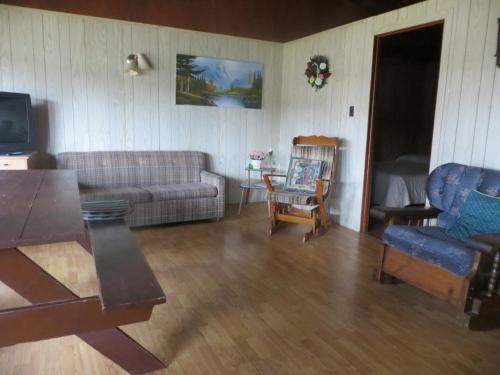 un soggiorno con divano e tavolo di MacIver's Motel and Camp a Blind River