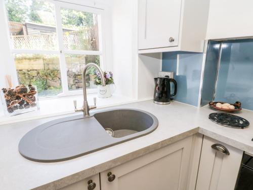 a kitchen counter with a sink and a window at Crooked Cottage in Kirkbymoorside