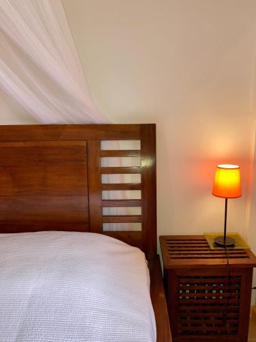a bedroom with a bed and a table with a lamp at Habitation Bellevue in Sainte-Anne