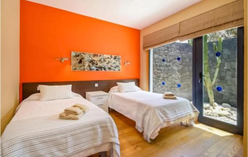 2 camas en una habitación con paredes de color naranja en Awesome Home In Playa Blanca With Sauna, en Playa Blanca