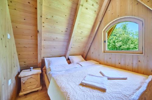 a bedroom with a bed in a wooden cabin at Houses Amanet in Kolašin