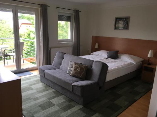 1 dormitorio con cama, sofá y ventana en Luca Apartments, en Zalakaros