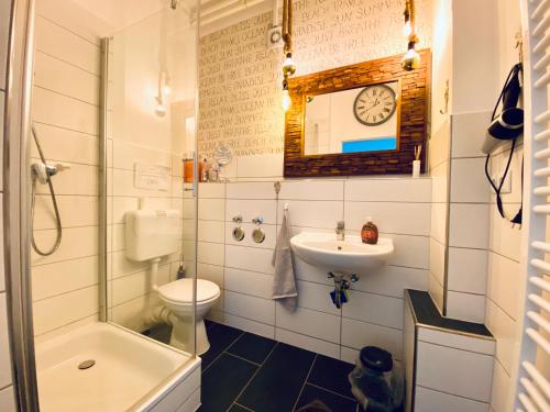 La salle de bains est pourvue de toilettes avec lavabo et d'une horloge murale. dans l'établissement Ankerplatz-1-Kiel, à Kiel