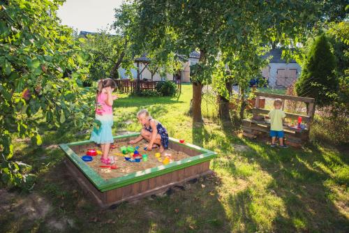 a little girl and a boy playing in a sandbox at Siedlisko Bolek in Nadrybie