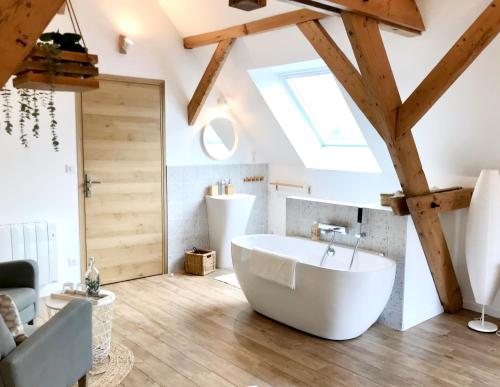 a bathroom with a large white tub in a attic at Aux 2 girouettes in Merville