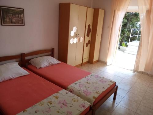 een slaapkamer met 2 bedden en een deur naar een balkon bij Apartman Laus in Zavalatica