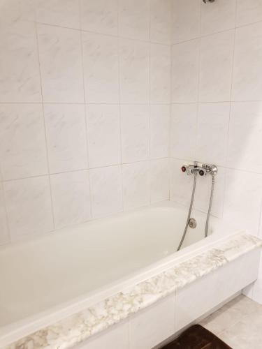 a white bath tub with a shower in a bathroom at El Rincón de Cambados in Cambados