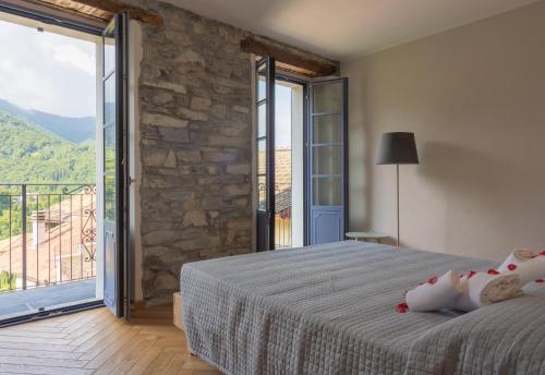 a bedroom with a bed and a large window at Cà Piodèe in Faggeto Lario 