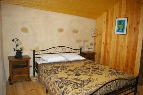 ein Schlafzimmer mit einem Bett und einer Holzwand in der Unterkunft Gîte l'appel de la Forêt in Betplan