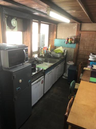 a kitchen with a sink and a stove top oven at ゲストハウス+カフェわ　１日１組限定！ 築１００年の農家の古民家で宿泊体験、薪でお風呂沸かせます。焚き火もできます。 in Kannami