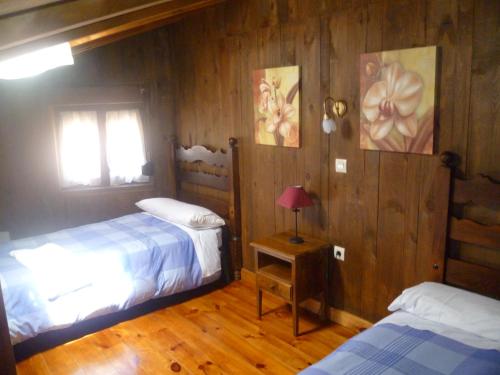 a bedroom with two beds and a table with a lamp at Artesano II in Navarredonda de Gredos