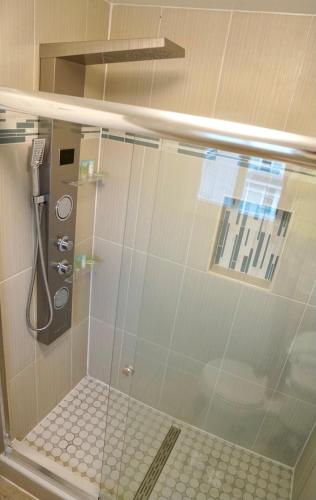 a bathroom with a shower with a glass door at Coastal Sands Inn in Wildwood
