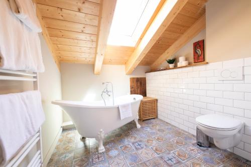 Haus Ludwig Alpenkrähe في غارميش - بارتنكيرشين: حمام مع حوض استحمام أبيض ومرحاض