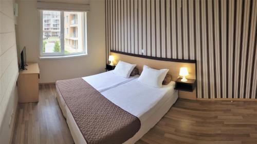 - une chambre avec un grand lit et 2 fenêtres dans l'établissement Obzor Beach Resort Apartment G-109, à Obzor
