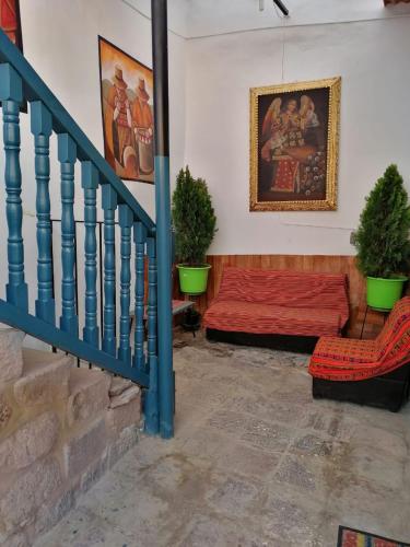 a living room with a red bed and a staircase at La Estación San Pedro in Cusco