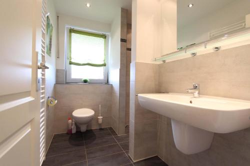 a bathroom with a sink and a toilet at Haus Heckenrose Whg 5 EG in Kellenhusen