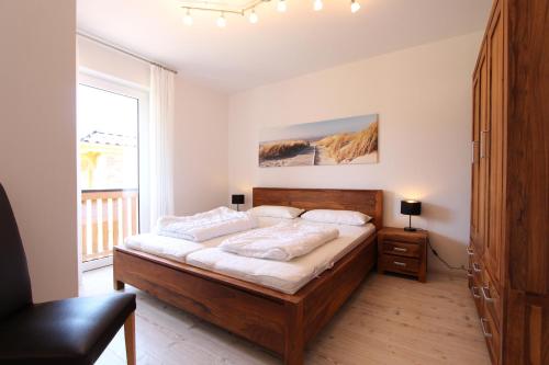 a bedroom with a large wooden bed in a room at Haus Heckenrose Whg 5 EG in Kellenhusen