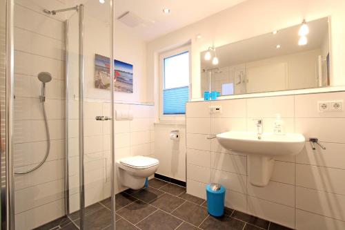 a bathroom with a toilet and a sink and a shower at Merlin 3 Waldstr 20 h in Kellenhusen
