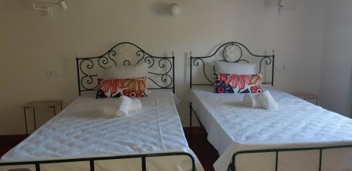 アフィフェにあるCasa do Generalのベッド2台が隣同士に設置された部屋です。