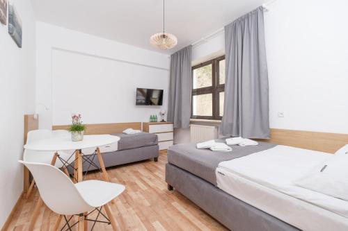 a bedroom with two beds and a table and a chair at Ośrodek Perełka Bieszczady in Cisna