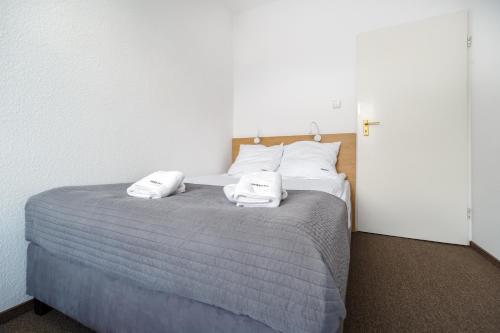 a bedroom with a bed with two towels on it at Ośrodek Perełka Bieszczady in Cisna