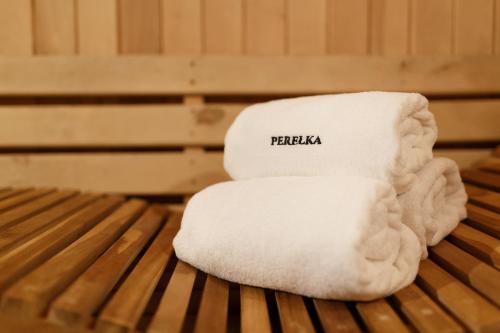 a stack of towels sitting on a wooden bench at Ośrodek Perełka Bieszczady in Cisna
