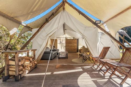 a tent with two chairs and a couch in it at Under Canvas Great Smoky Mountains in Pigeon Forge
