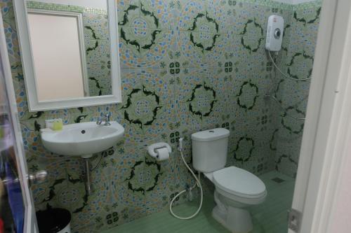 y baño con aseo, lavabo y espejo. en Tubkaek mansion, en Tab Kaek