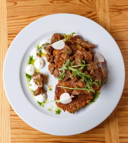 a plate of food with meat on a table at Ośrodek Perełka Bieszczady in Cisna