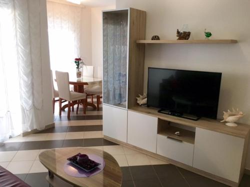 a living room with a flat screen tv in a cabinet at Apartment Mirella in Umag