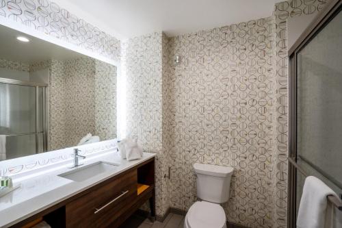 a bathroom with a toilet and a sink and a mirror at Holiday Inn Hotels Batesville, an IHG Hotel in Batesville