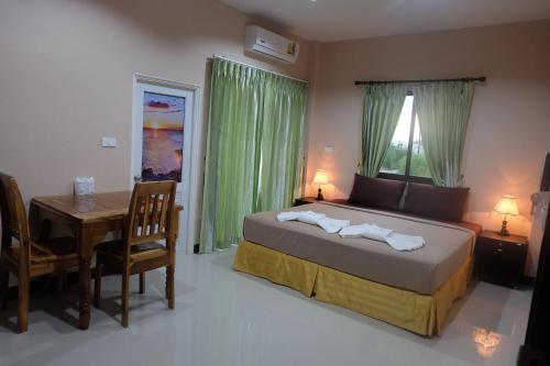 a bedroom with a bed and a desk and a table with a table at Tubkaek mansion in Tab Kaek Beach