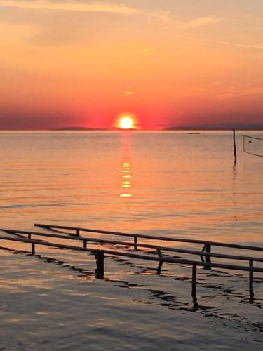 a bench on the beach with the sunset in the background at Apartment Mirella in Umag