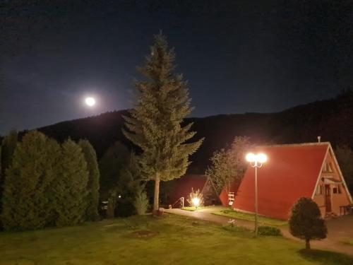 a barn at night with the moon in the sky at Perełka Bieszczady Domki in Cisna