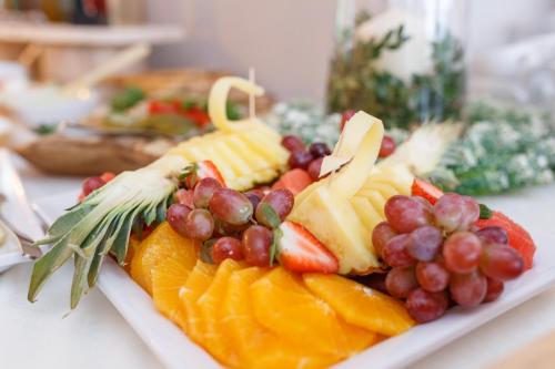 a plate of fruit with grapes oranges and cheese at Perełka Bieszczady Domki in Cisna