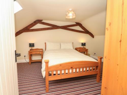 a bedroom with a bed and two night stands at Battens in Northleigh