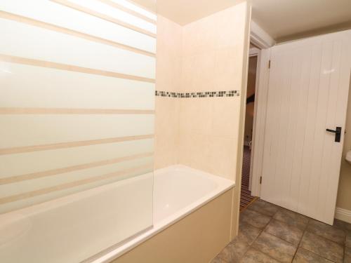 a bathroom with a tub and a shower stall at Battens in Northleigh