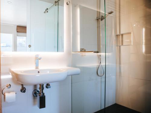 La salle de bains est pourvue d'un lavabo et d'une douche. dans l'établissement Astor Inn, à Wagga Wagga