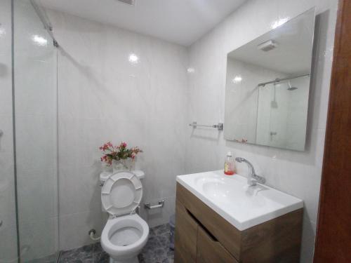 uma casa de banho com um WC, um lavatório e um espelho. em La 10B em Cartagena das Índias