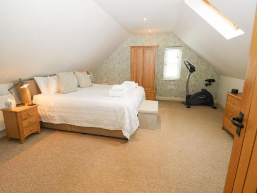 um quarto com uma grande cama branca num sótão em The Wash House em Bembridge