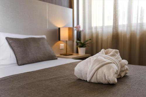 a white towel on a bed in a hotel room at Hotel Douro Inn in Tabuaço
