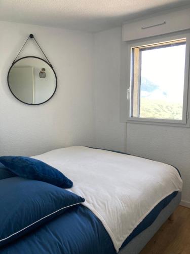 a bedroom with a bed with a mirror on the wall at Magnifique T3 au Pla D Adet (Saint Lary)grand confort entièrement refait à neuf avec une vue exceptionnelle sur la vallée in Saint-Lary-Soulan